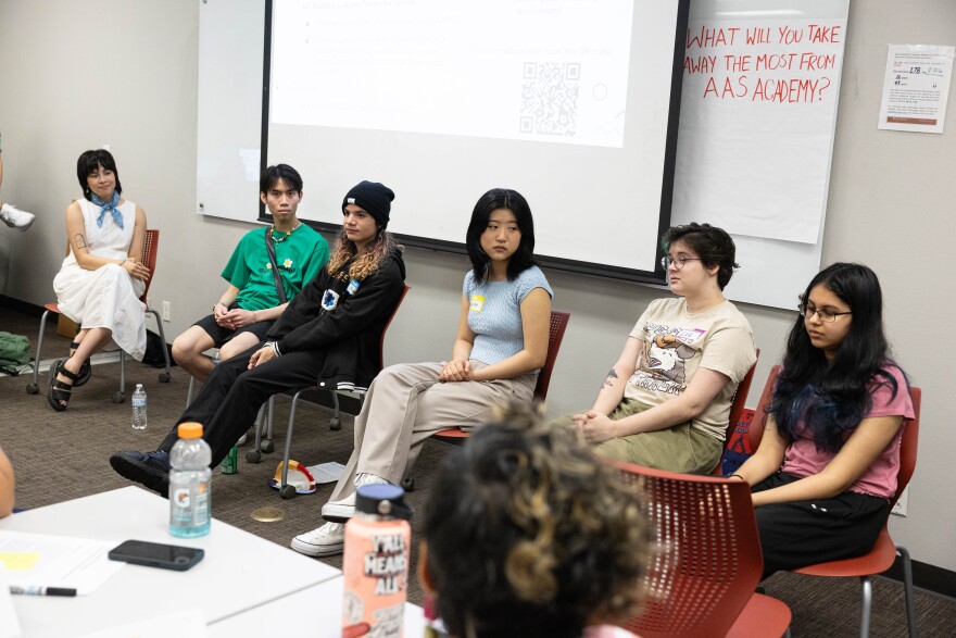 Round Rock ISD teacher Annie Nguyen and five of the students who took the Asian American Studies class she taught sit in red plastic chairs at the front of a classroom. 