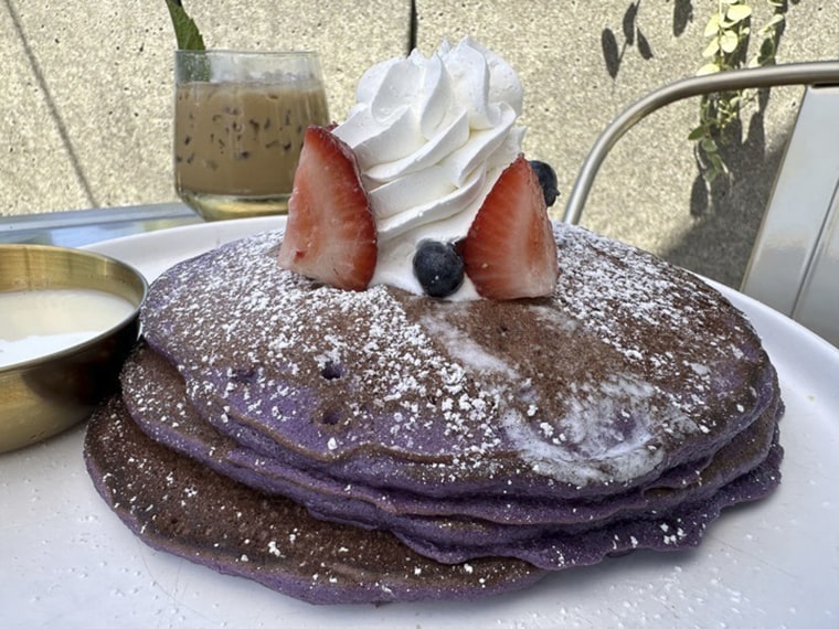 An order of "Ooh BAE Pancakes," ube pancakes with sea salt crema and coconut syrup, is served at Breaking Dawn restaurant in Los Gatos, Calif., on Sunday, Aug. 4, 2024. 