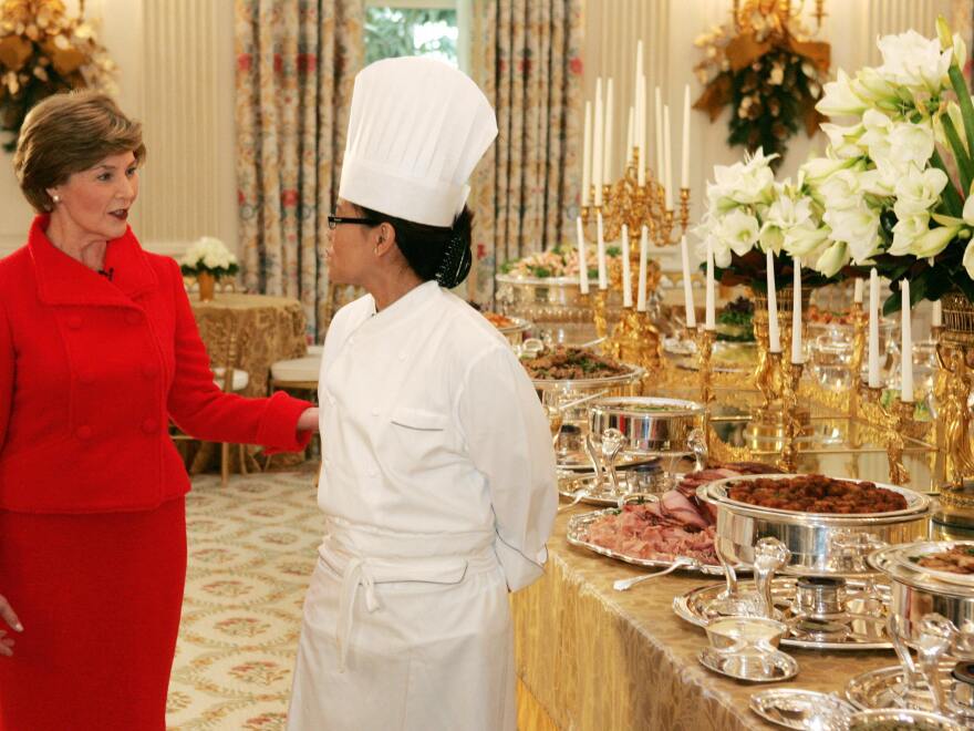 First Lady Laura Bush with Comerford next to samples of the food that will be served during holiday parties in the State Dining Room in 2007.