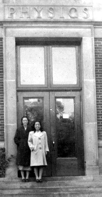 A couple of women standing in front of a building

Description automatically generated