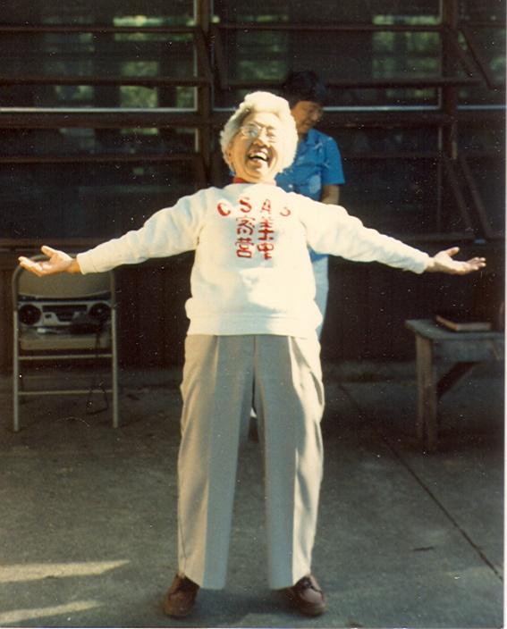 An old person with arms outstretched

Description automatically generated