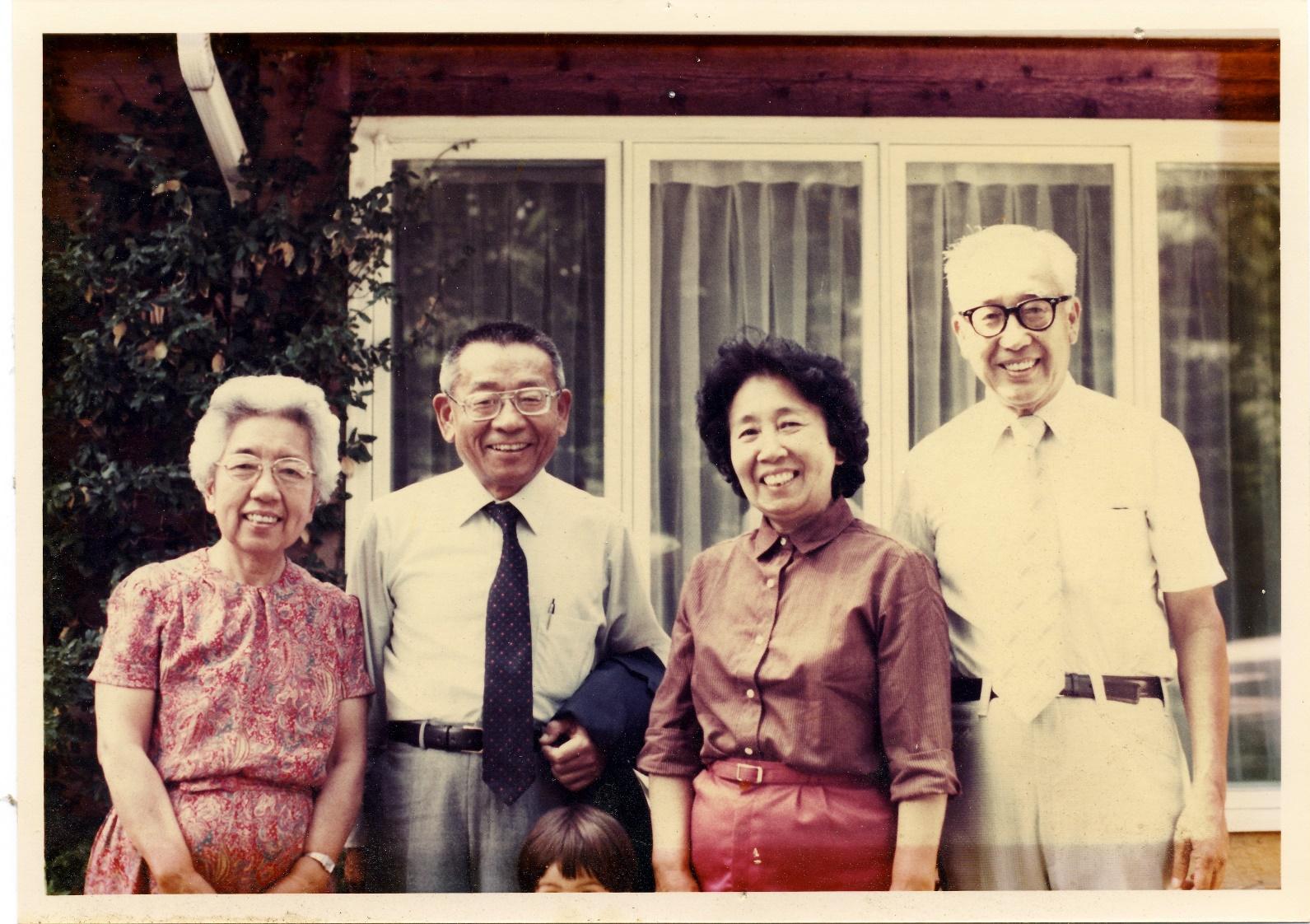 A group of people standing in front of a house

Description automatically generated